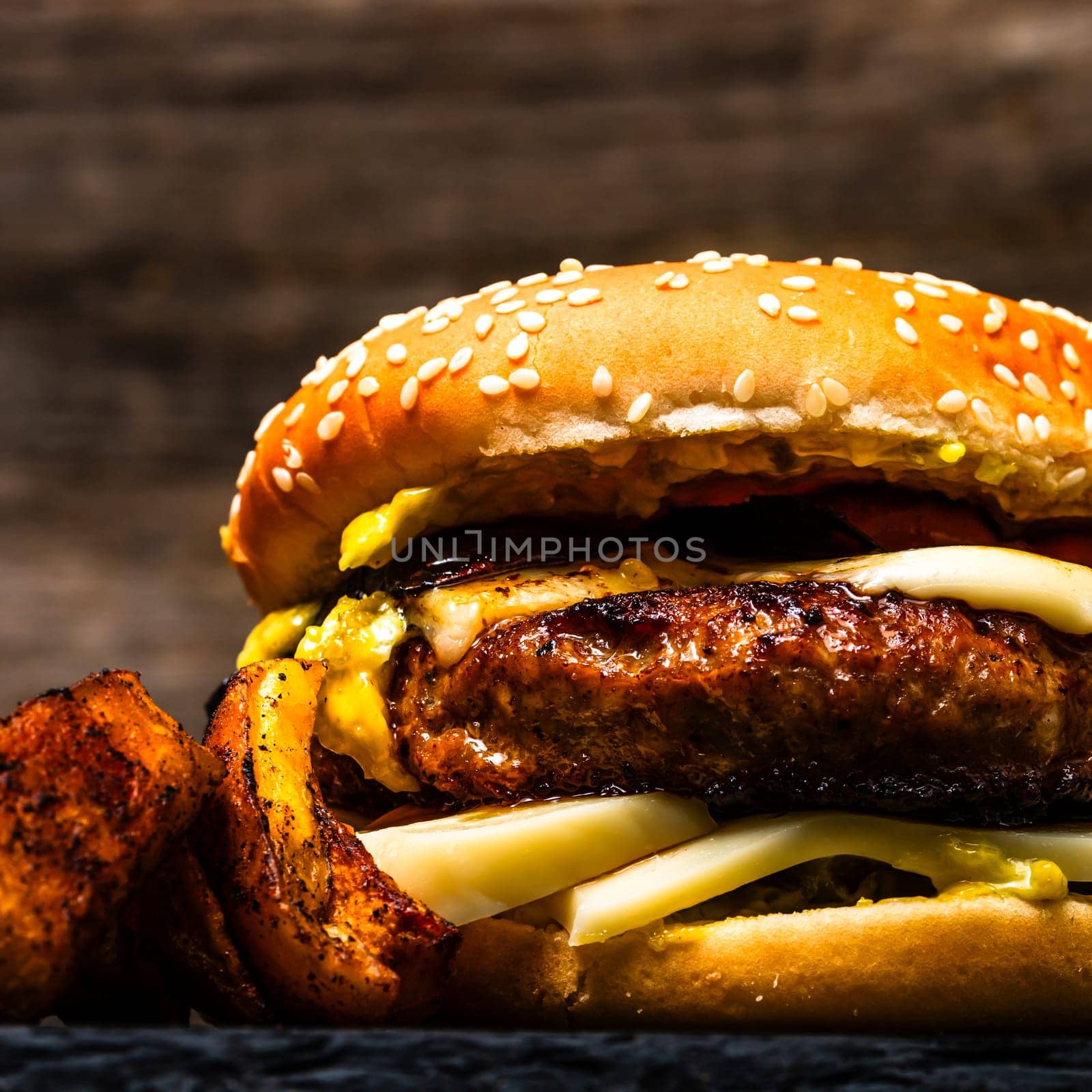 Tasty home made cheeseburger. Cheese burger with pickles, tomatoes, onion, melting cheese