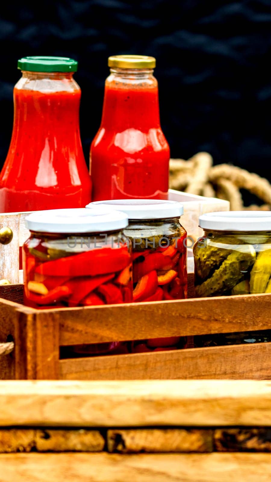 Bottles of tomato sauce, preserved canned pickled food concept isolated in a rustic composition.