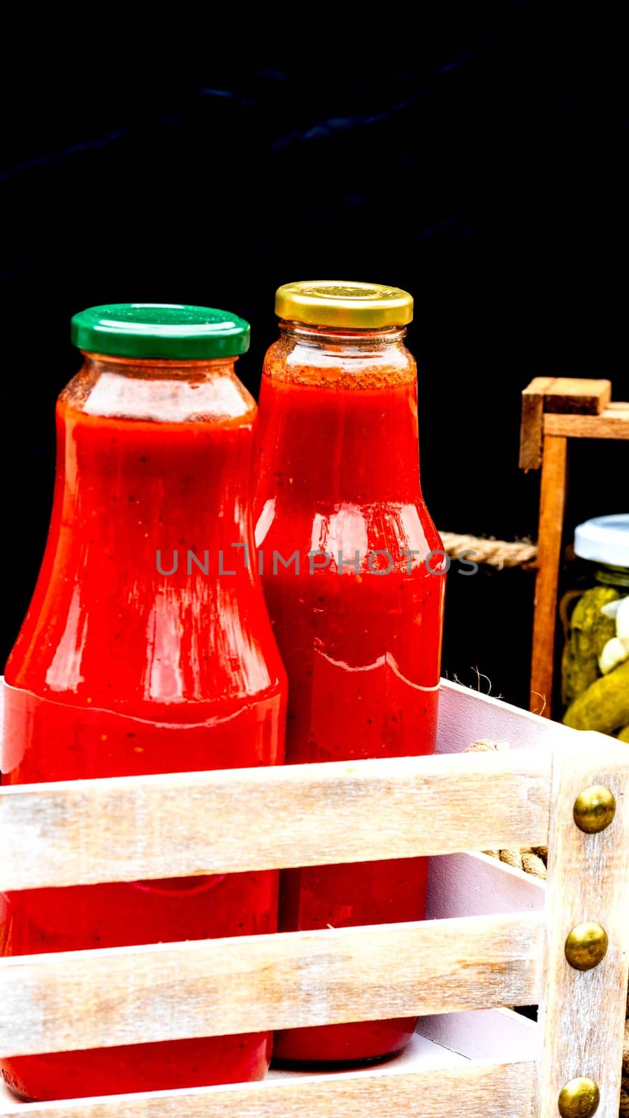 Bottles of tomato sauce, preserved canned pickled food concept isolated in a rustic composition.