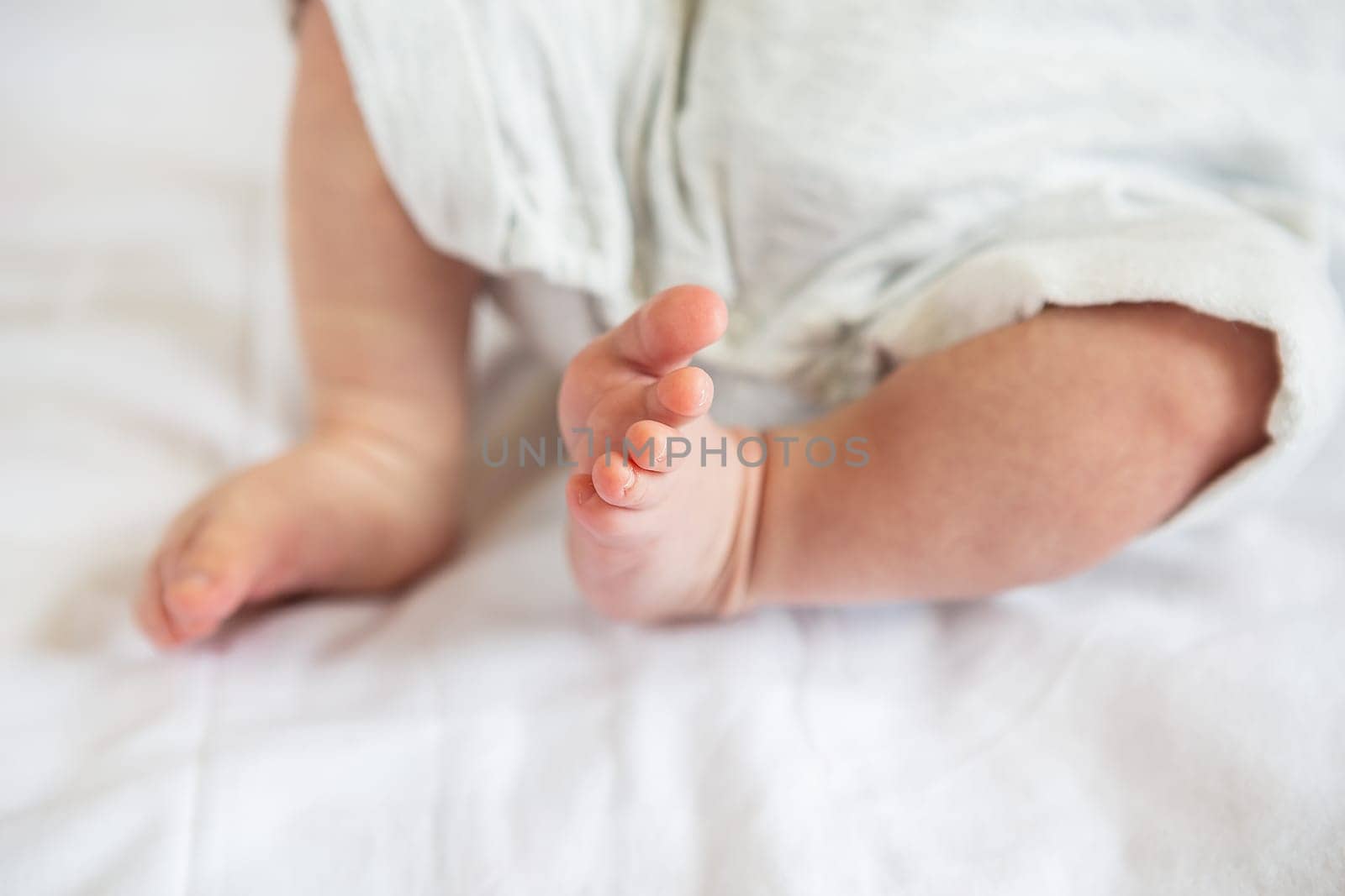 Small feet of a newborn baby. The concept of motherhood, breastfeeding