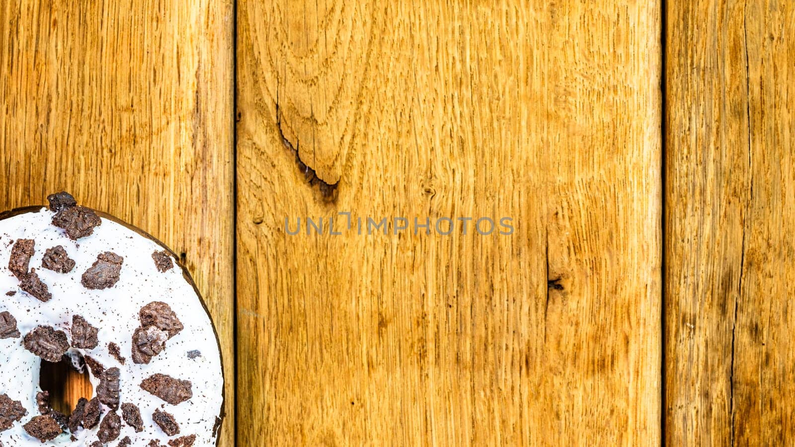 Colorful donuts on wooden table. Sweet icing sugar food with glazed sprinkles, doughnut with chocolate frosting. Top view with copy space