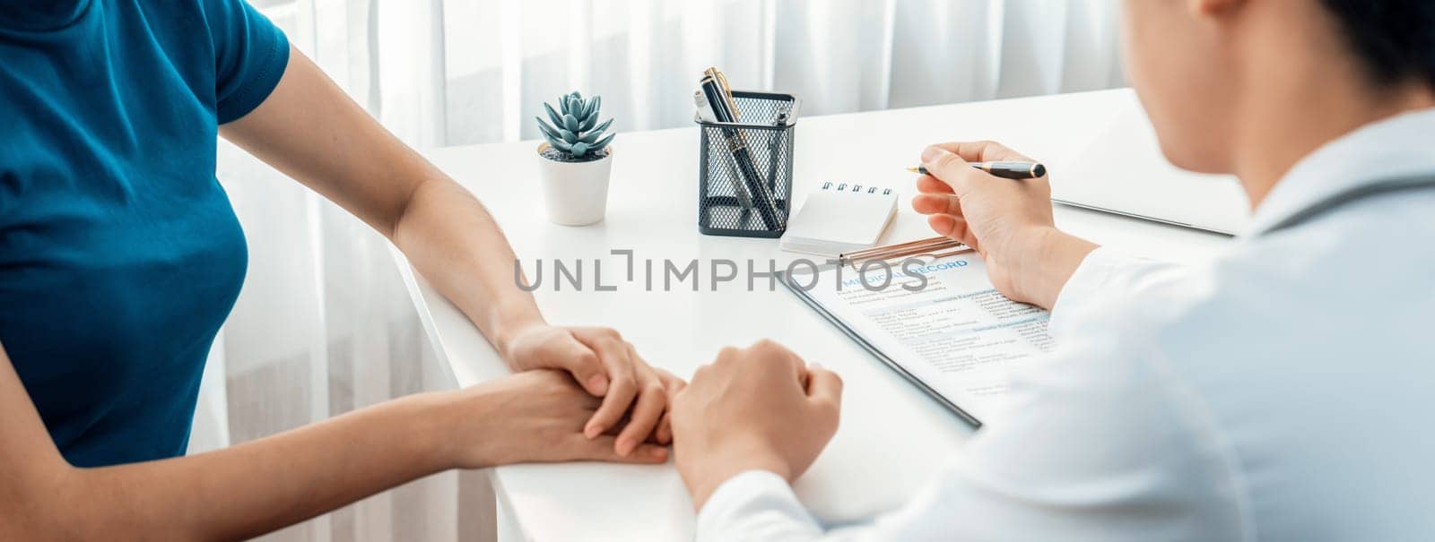 Patient attend doctor's appointment at clinic or hospital office, discussing medical treatment option and explaining diagnostic result while consoling and comforting patient. Panorama Rigid