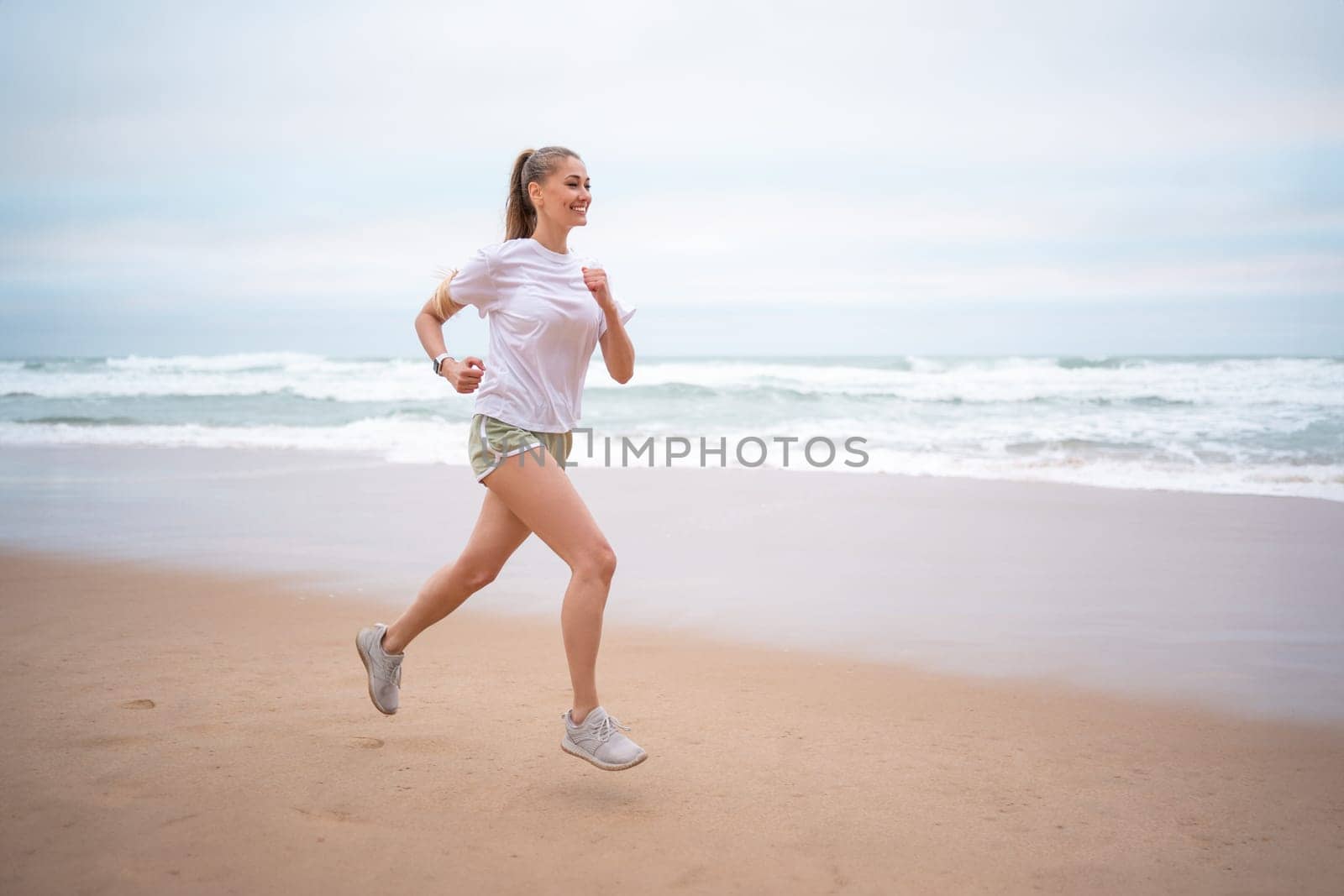 Woman running ocean beach summer morning by andreonegin