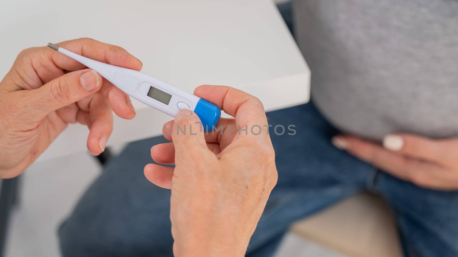 A pregnant woman visits a doctor. Therapist holding an electronic thermometer. by mrwed54