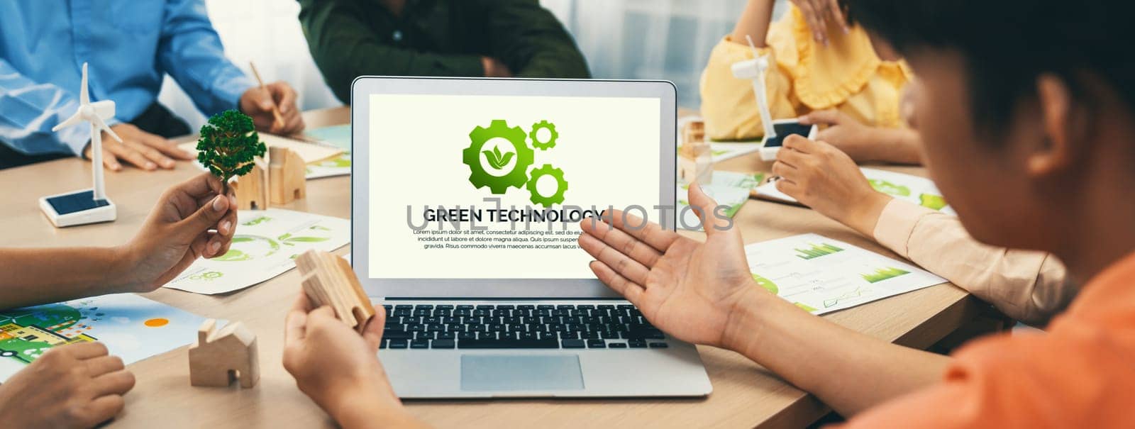 Green technology logo displayed on green business laptop while business team presenting green design to customer. ESG environment social governance and Eco conservative concept. Closeup. Delineation
