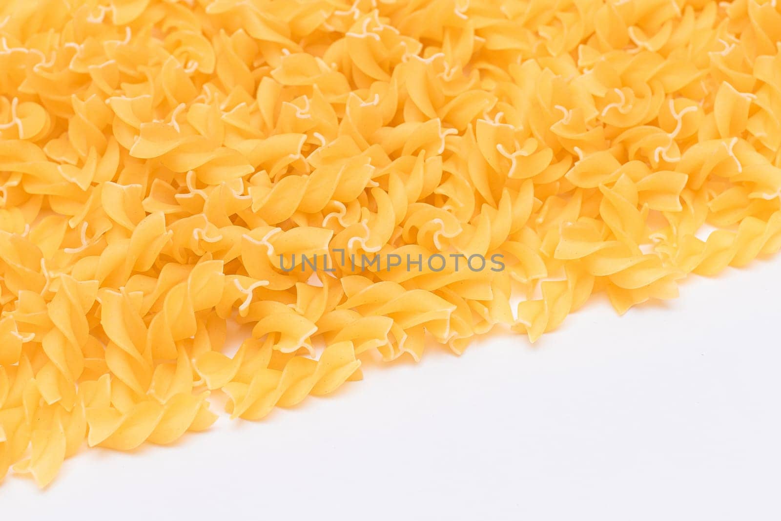Uncooked Fusilli Pasta with Copy Space on White Background. Raw and Dry Macaroni. Fat and Unhealthy Food - Flat Lay