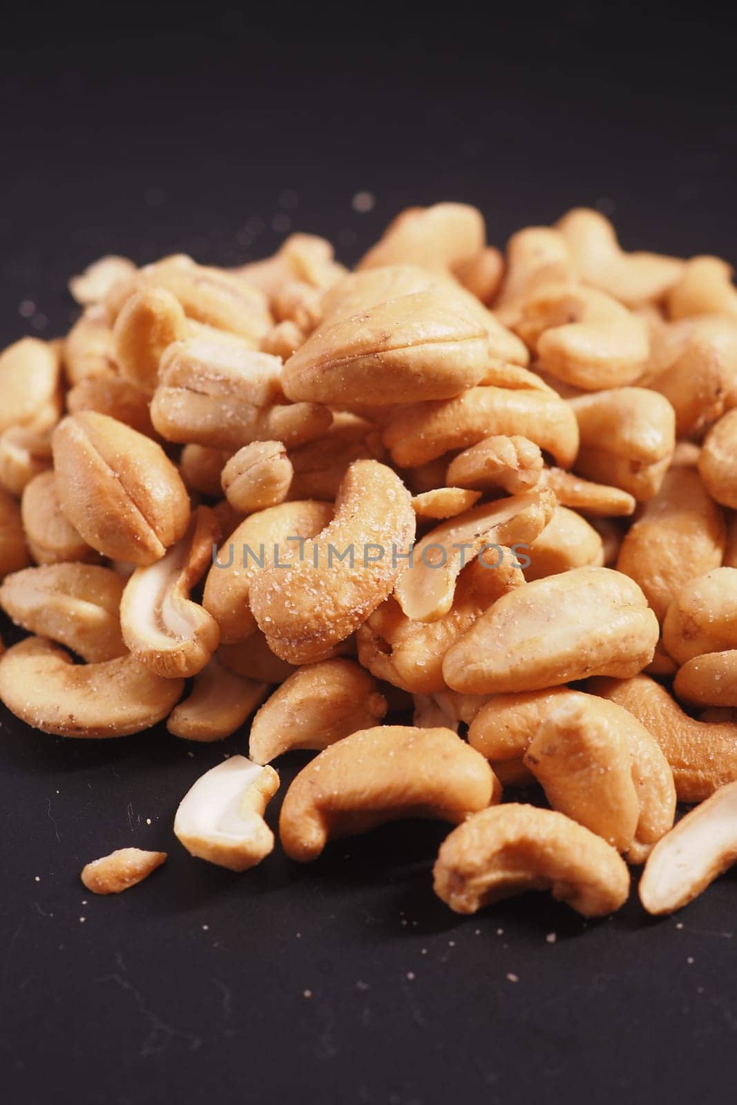 vertical shot of cashew nuts black color background by towfiq007