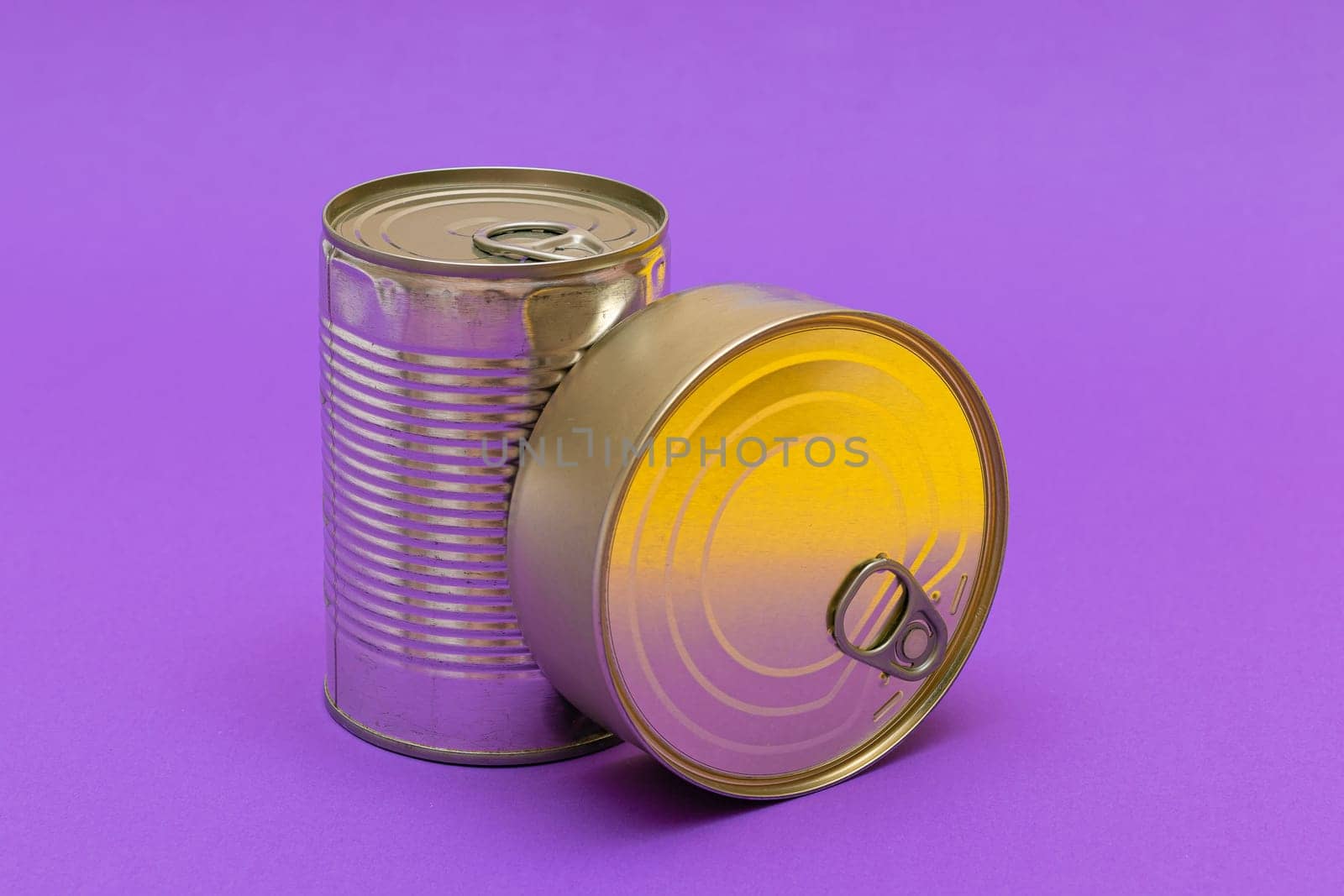 Unopened Tin Cans with Blank Edge on Violet Background. Canned Food. Aluminum Cans for Safe and Long Term Storage of Food. Steel Sealed Food Storage Containers