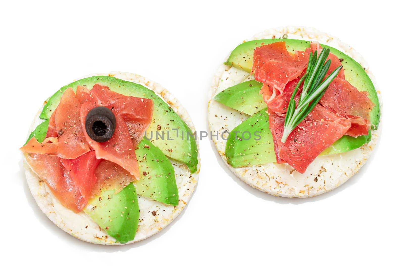 Rice Cake Sandwich with Avocado, Jamon, Olives and Rosemary - Isolated on White. Easy Breakfast. Quick and Healthy Sandwiches. Crispbread with Tasty Filling. Healthy Dietary Snack - Isolation