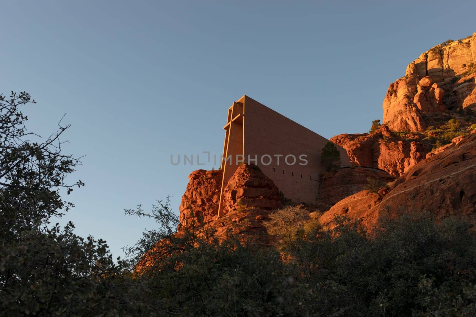 Chapel Of Holy Cross, Roman Catholic Chapel Built Into The Red Rock Buttes Of Sedona, Arizona, USA Within Coconino National Forest. Beautiful Church On Sunset, Attraction,Spiritual Place. Horizontal. by netatsi