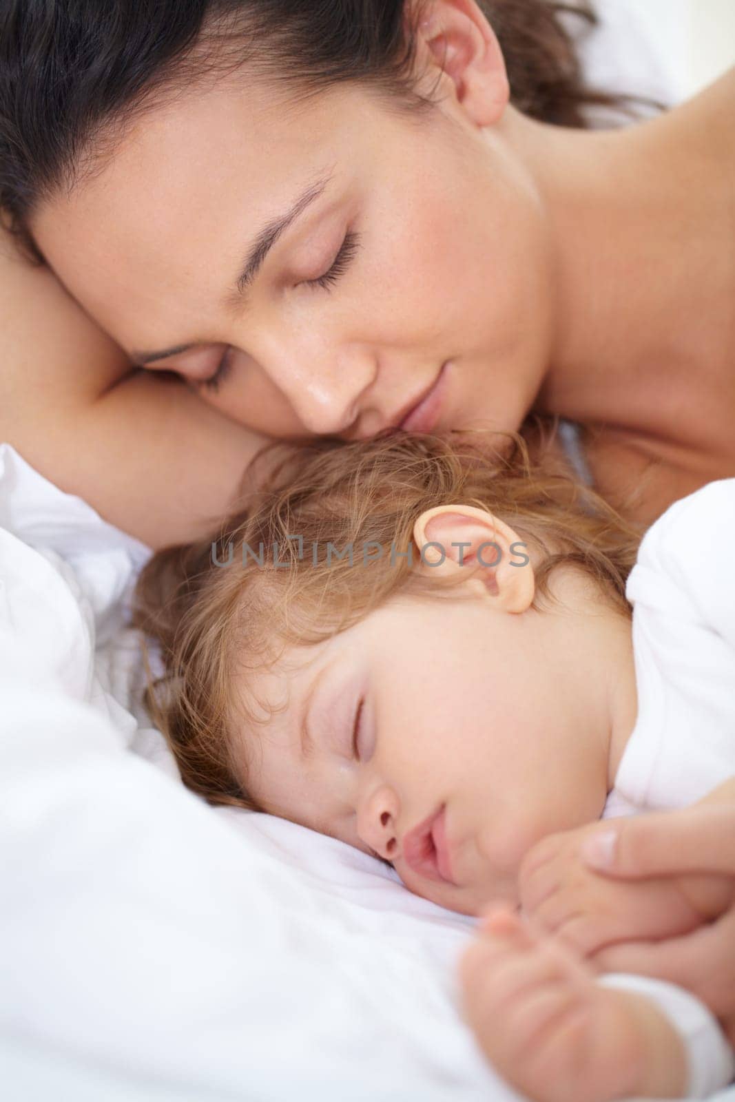 Mom, baby and kid sleeping on bed together for calm break, peace or dreaming to relax at home. Face of tired mother, young child and cozy nap for newborn development, healthy childhood growth or rest by YuriArcurs
