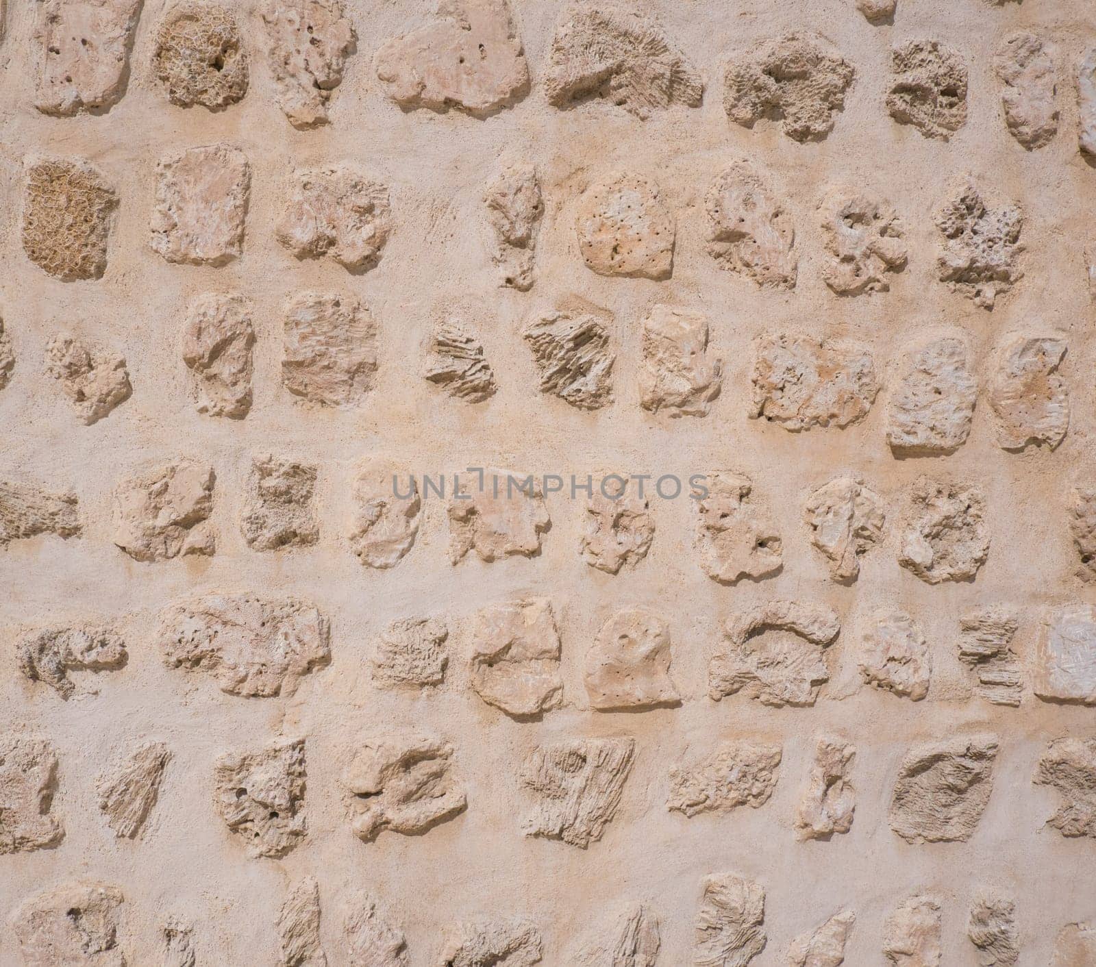 Traditional stone, coral and adobe wall in Sharjah emirate in the United Arab Emirates. Such hand plastered walls were made for centuries in the Arabian Gulf with materials from the desert and sea