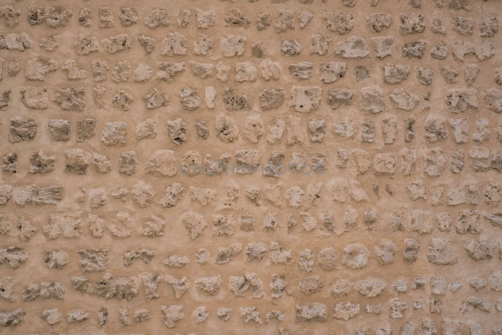 Traditional stone, coral and adobe wall in Sharjah emirate in the United Arab Emirates. Such hand plastered walls were made for centuries in the Arabian Gulf with materials from the desert and sea