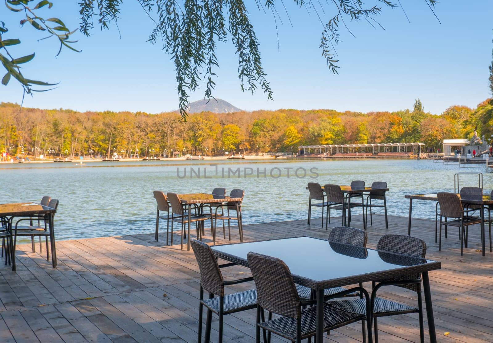 Recreation area in the city park. Outdoor tables and benches by the lake for relaxing and eating.