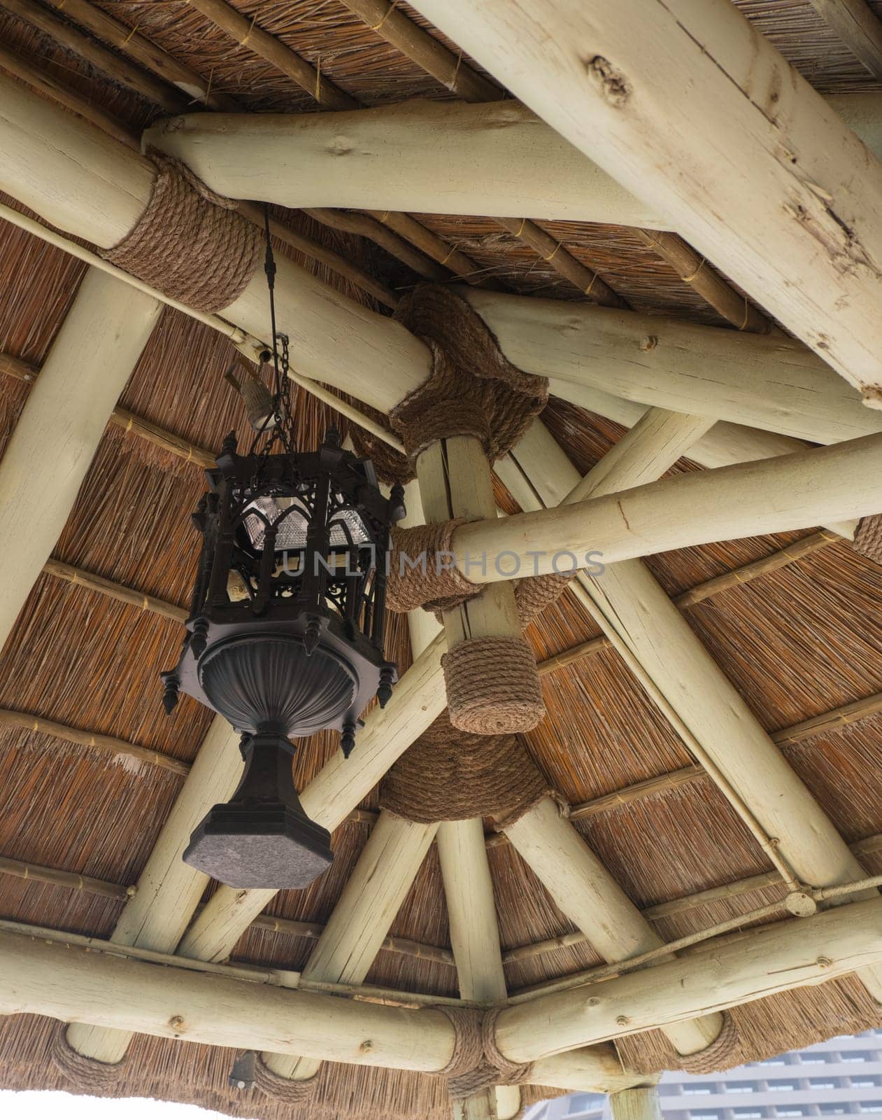 The facade of the summer gazebo with decorative elements and lamps for lighting on the seashore by Ekaterina34