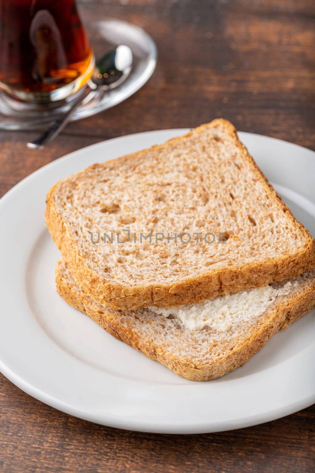 Cream cheese sandwich on white porcelain plate on wooden table