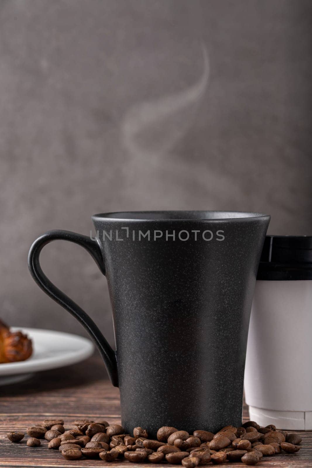 Relaxing americano coffee in black porcelain cup and take away cup on wooden table by Sonat