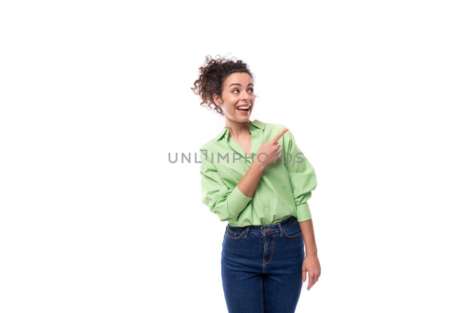 portrait of a young charming brunette businesswoman with curly hair gathered in a bun dressed in an office light green shirt on a white background with copy space by TRMK