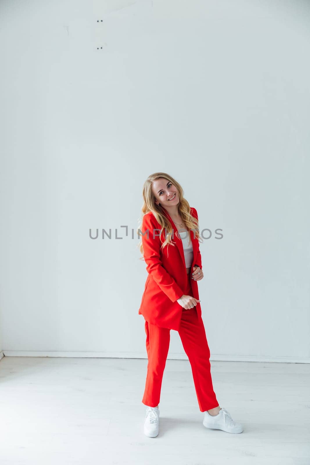 Portrait of a beautiful blonde woman in a red business suit
