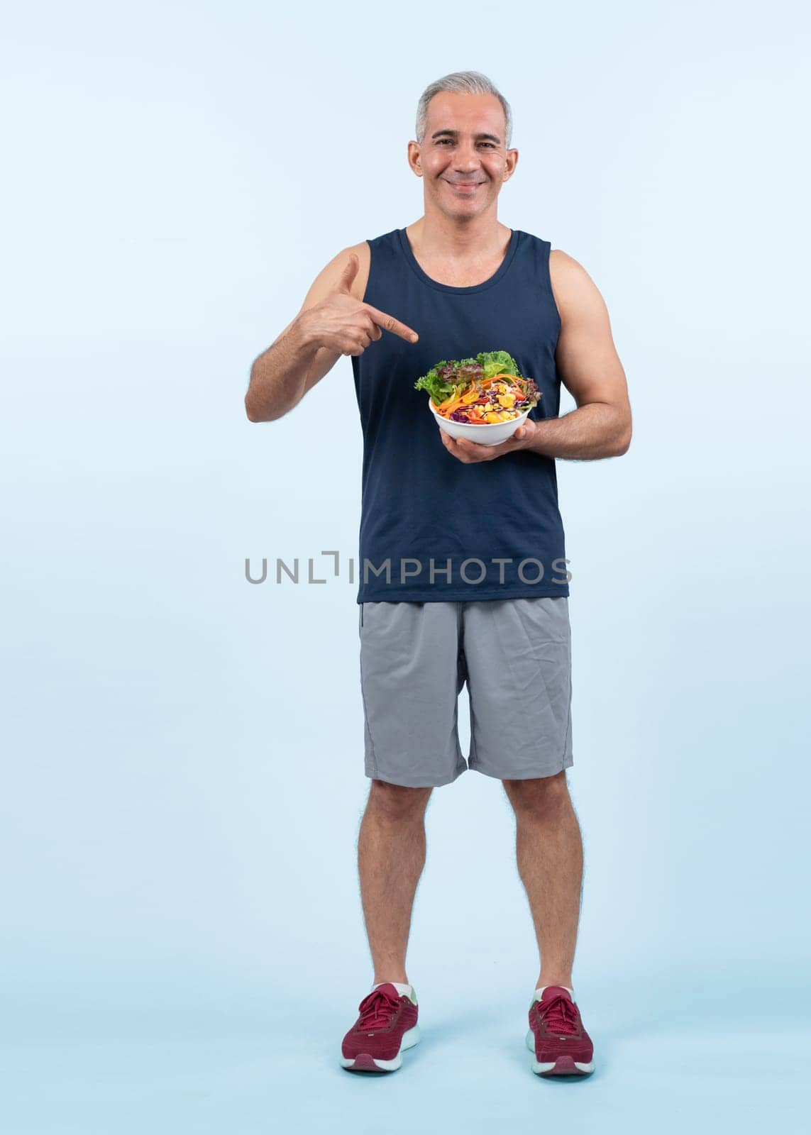 Happy smile senior man portrait holding bowl of vegan fruit and vegetable on isolated background. Healthy senior people with healthy vegetarian nutrition and body care lifestyle. Clout