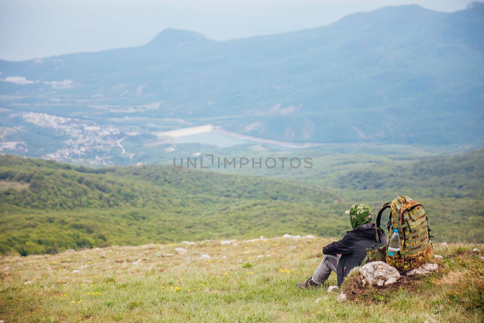 a man with a backpack on the mountain on a hike trip by Simakov