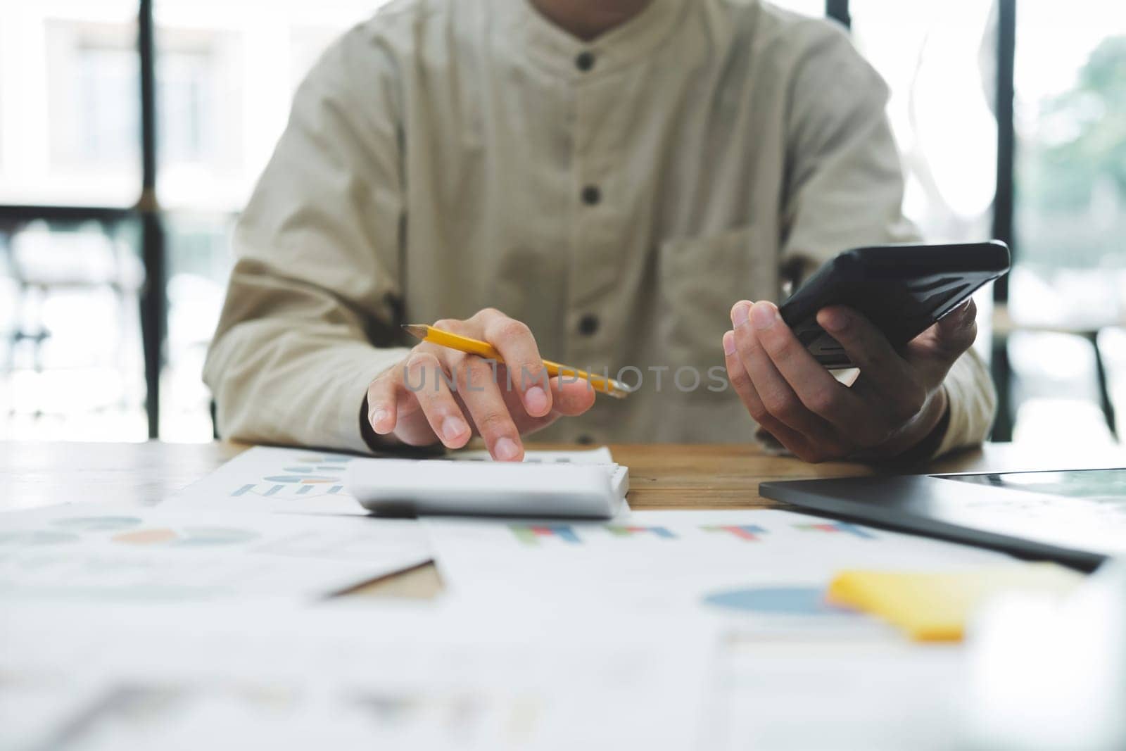 Accountant or banker calculate the cash bill to pay Tax, Budget, and Tax planning concept. Businessman calculating annual tax and using mobile phone.