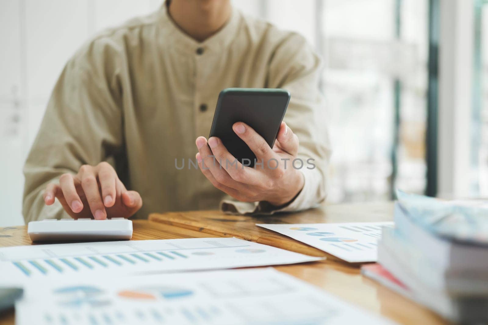 Accountant or banker calculate the cash bill to pay Tax, Budget, and Tax planning concept. Businessman calculating annual tax and using mobile phone.