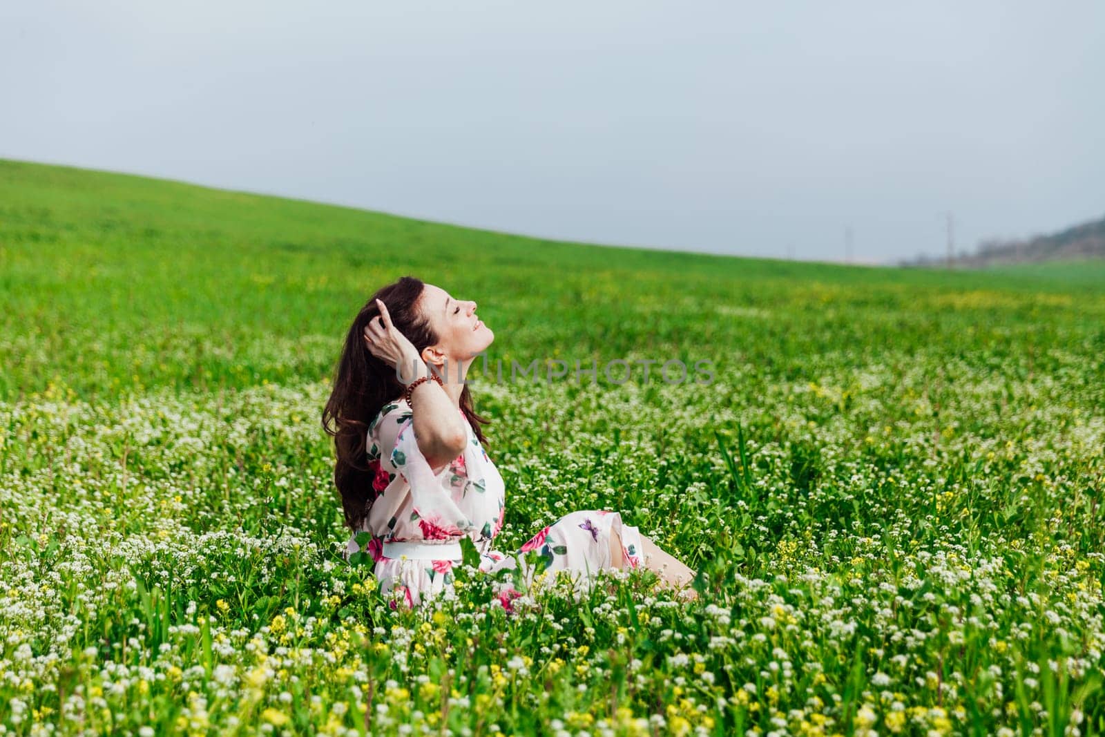 beautiful woman sitting in a green clearing in nature