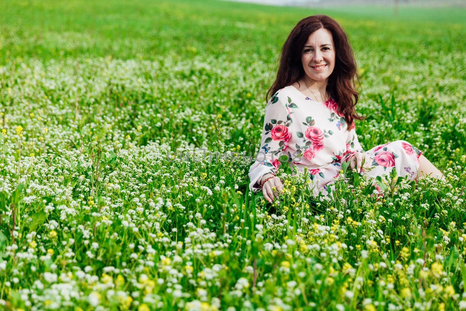 beautiful woman sitting in a green clearing in nature