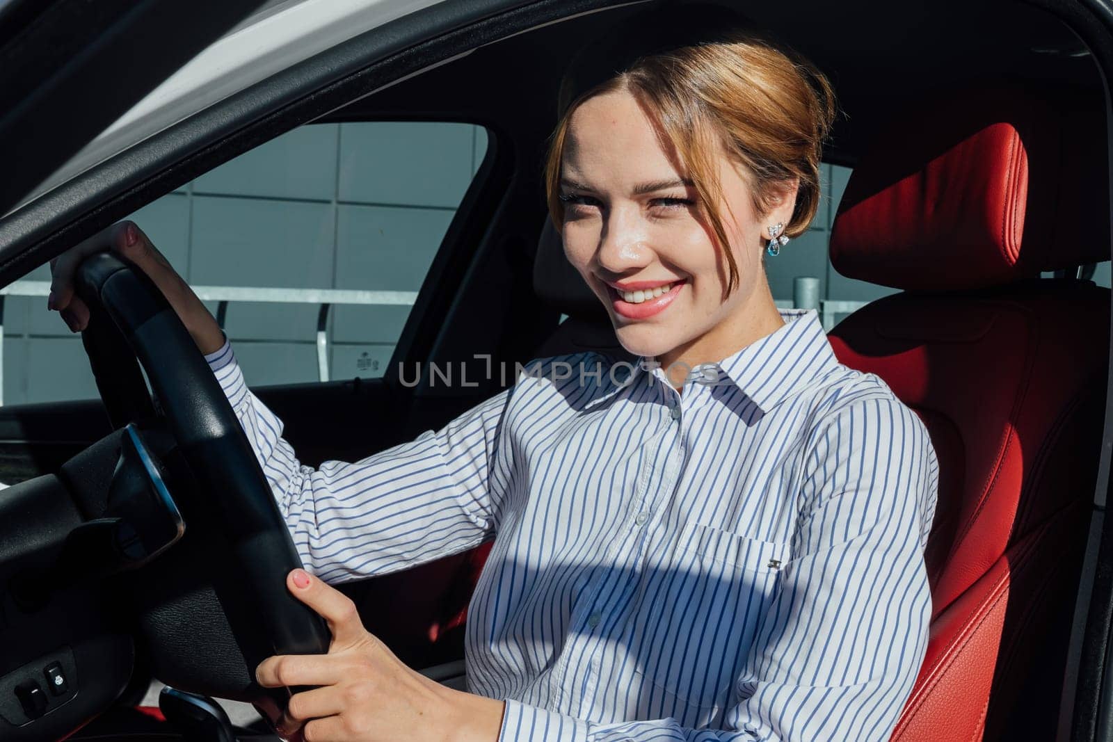 a woman sitting in a car behind the wheel of a driver ride on the road