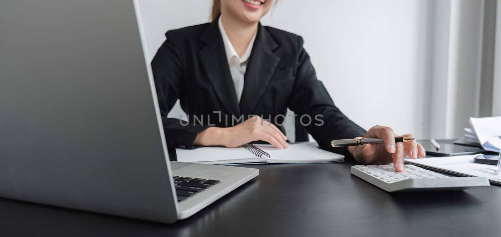 close up, Attractive young businesswoman working using laptop on corporate charts and graphs on wooden table in office room.
