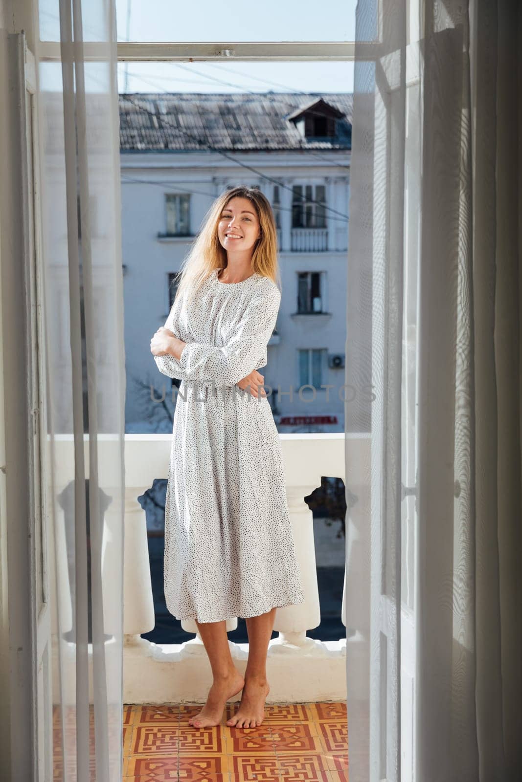 blonde stands on the balcony in the apartment room by Simakov