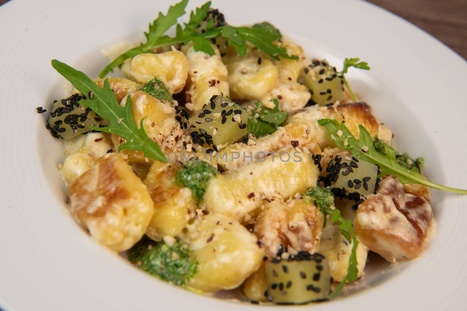 RECIPE FOR POTATO GNOCCHI WITH ROCKET SALAD PESTO AND CREAMY PARMESAN SAUCE. High quality photo