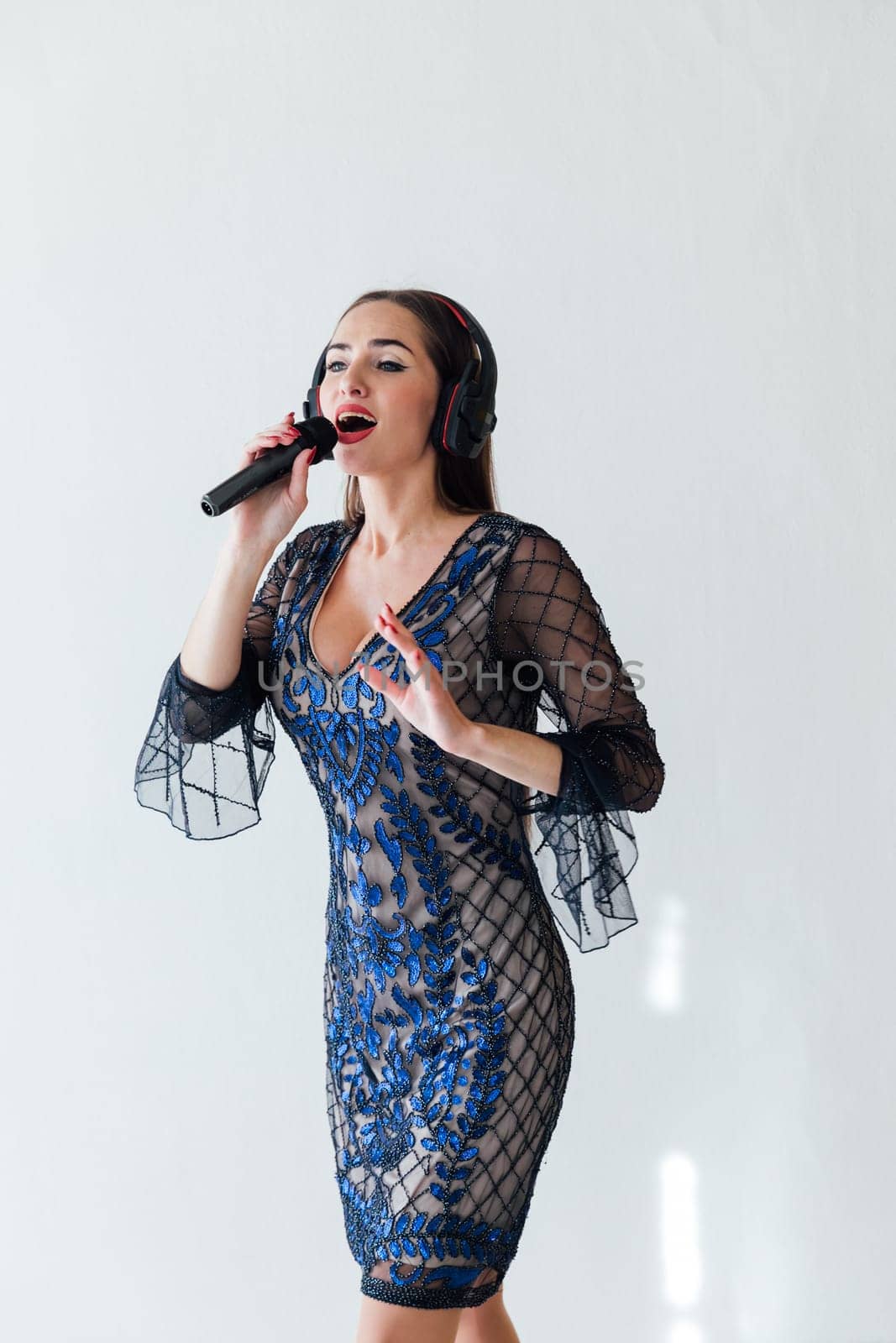 a female singer sings song into microphone in headphones in karaoke