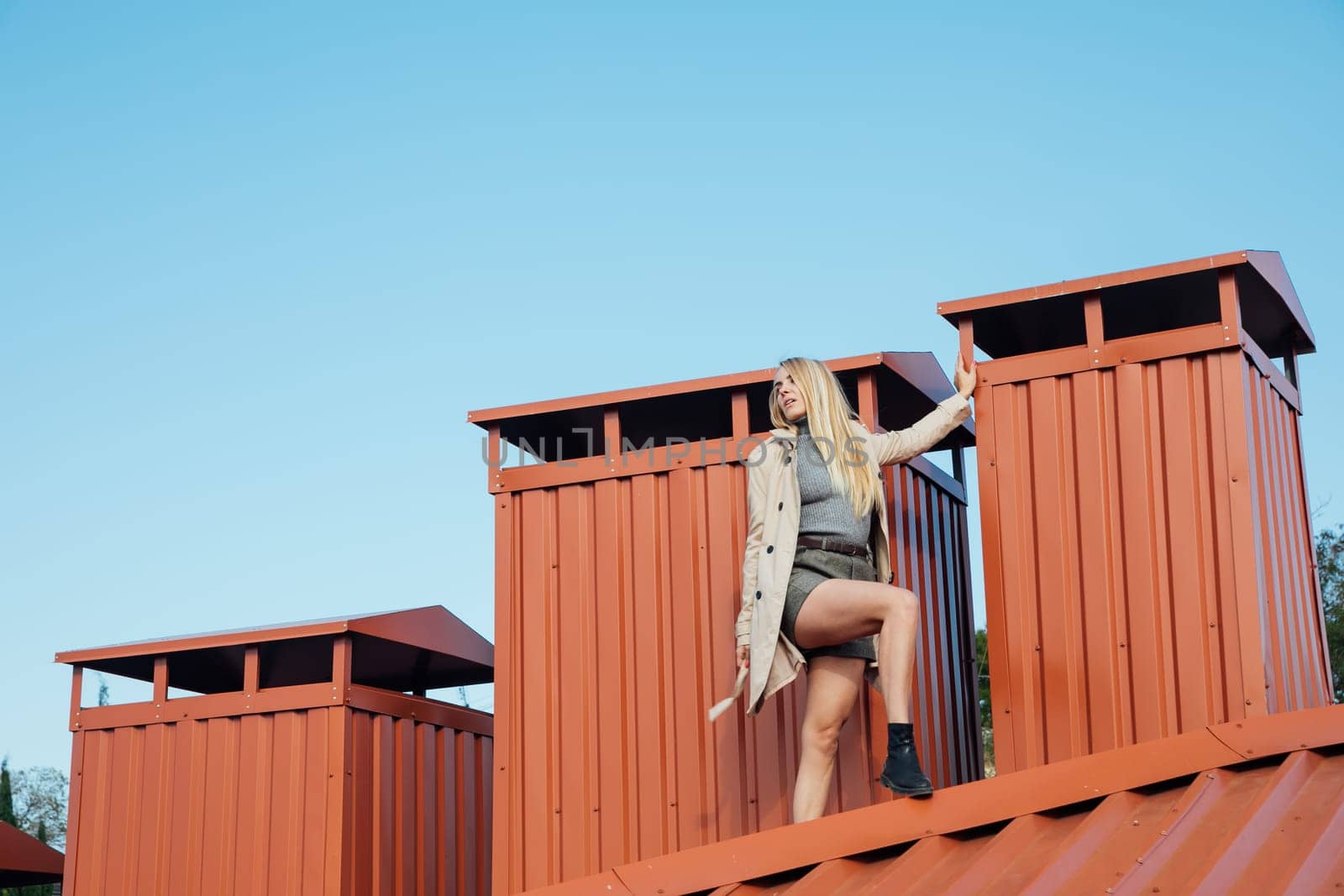 beautiful blonde woman on the roof of house on the street