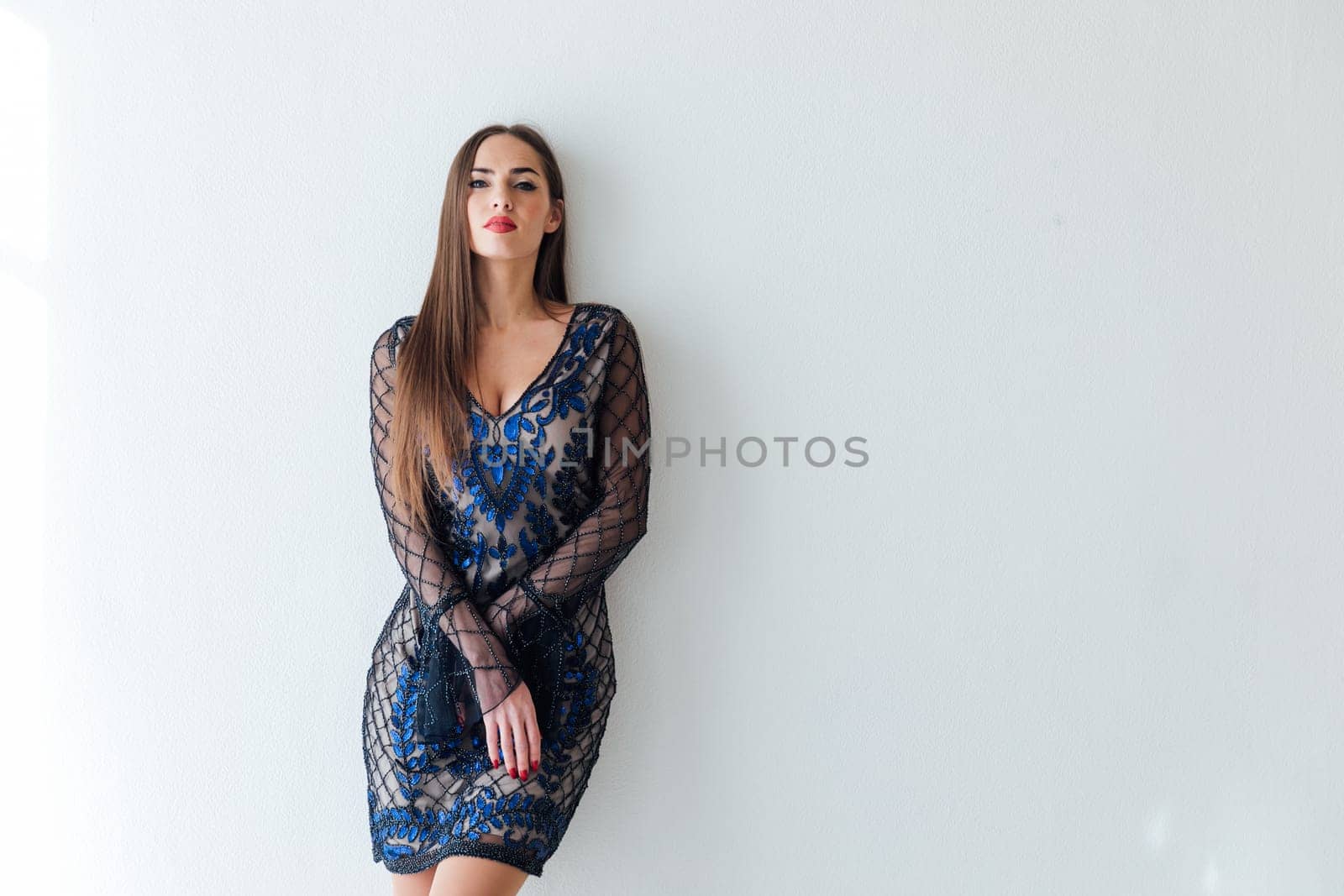 beautiful fashionable woman stands on a white background in a bright room