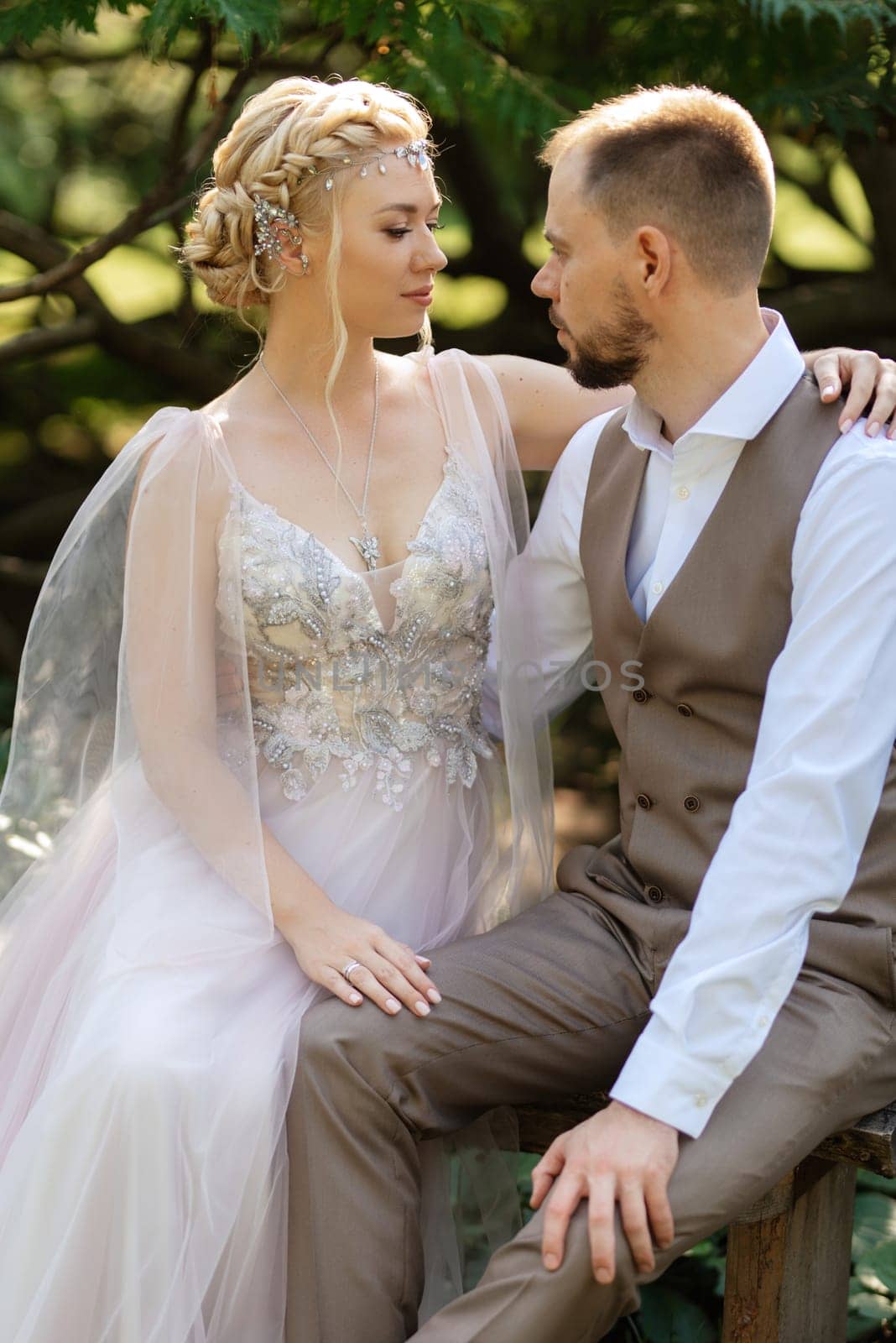 wedding walk of the bride and groom in a coniferous park in summer in elven accessories