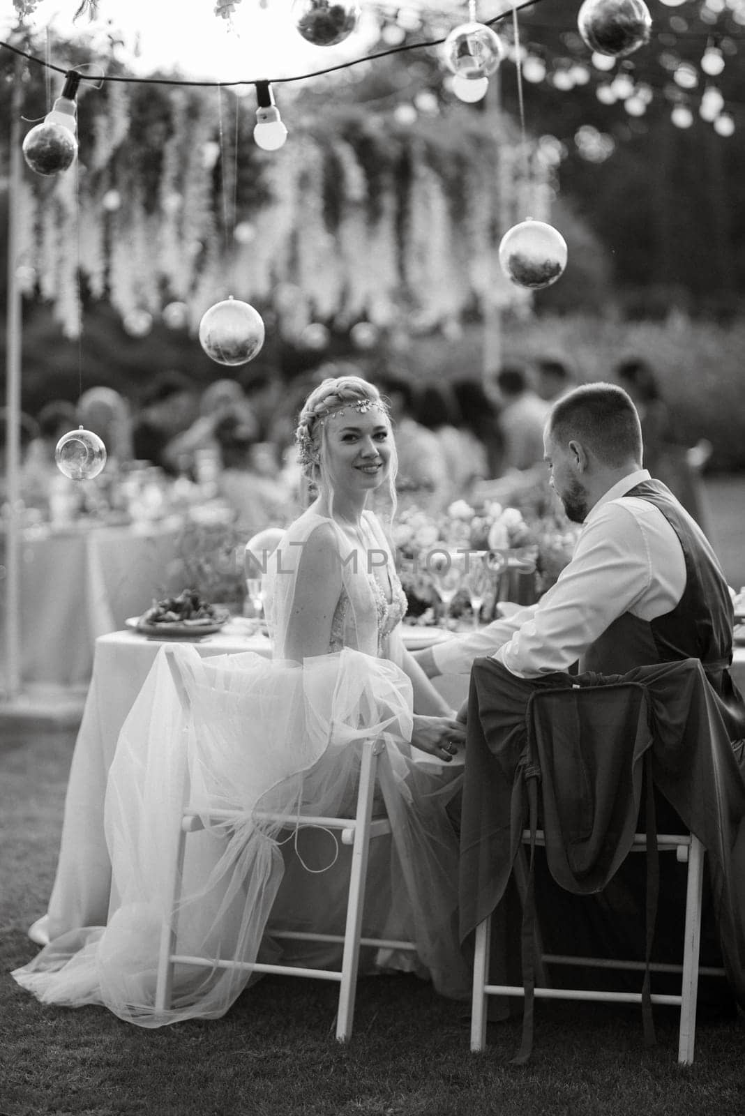 evening wedding family dinner in the forest with light bulbs and candles