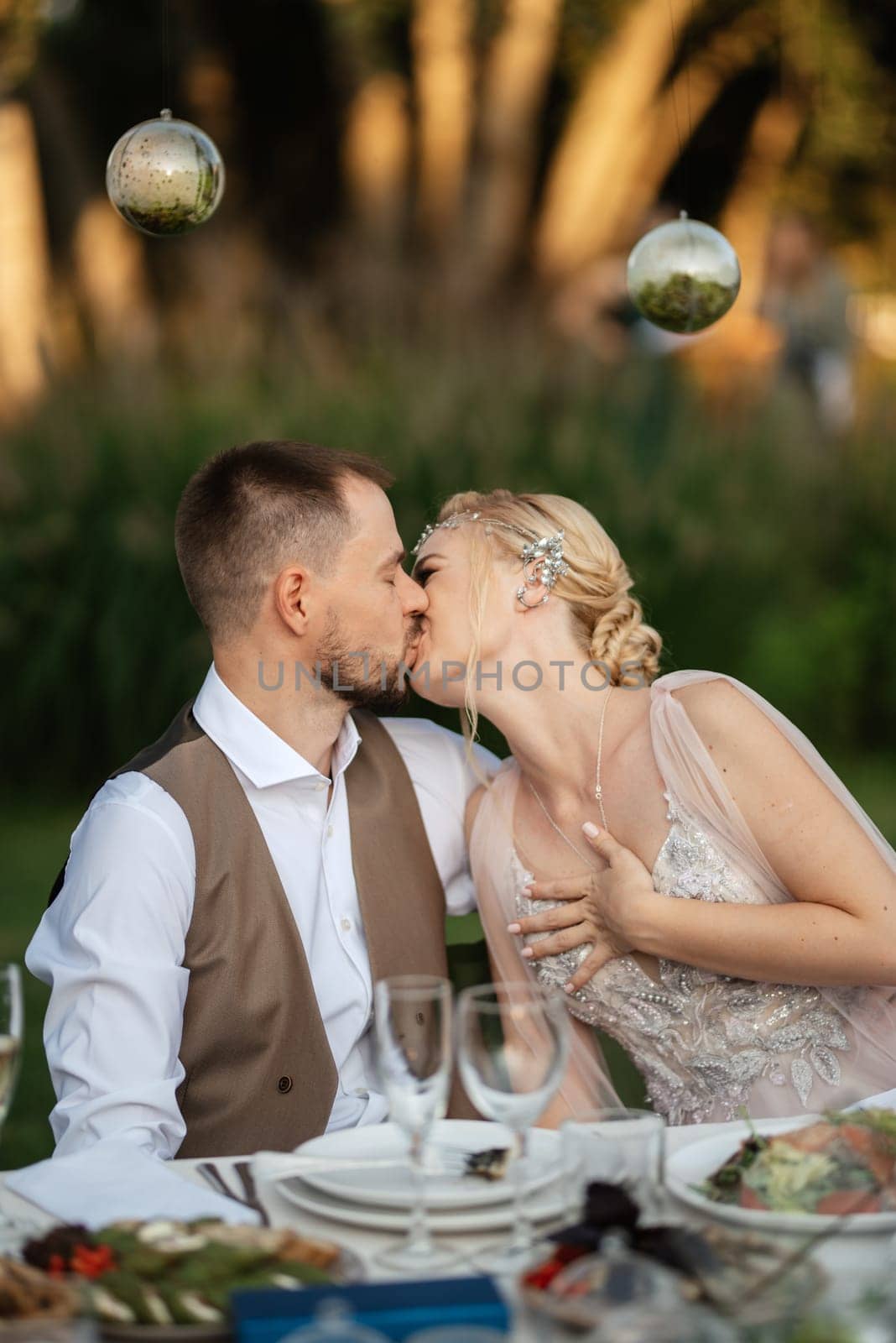 evening wedding family dinner in the forest with light bulbs and candles