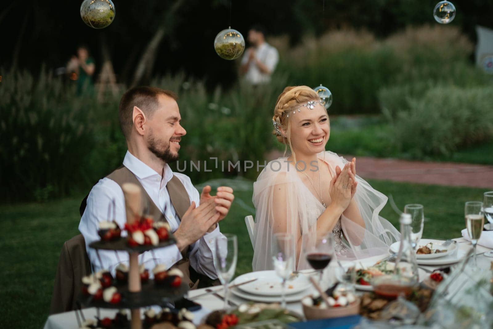 evening wedding family dinner in the forest with light bulbs and candles