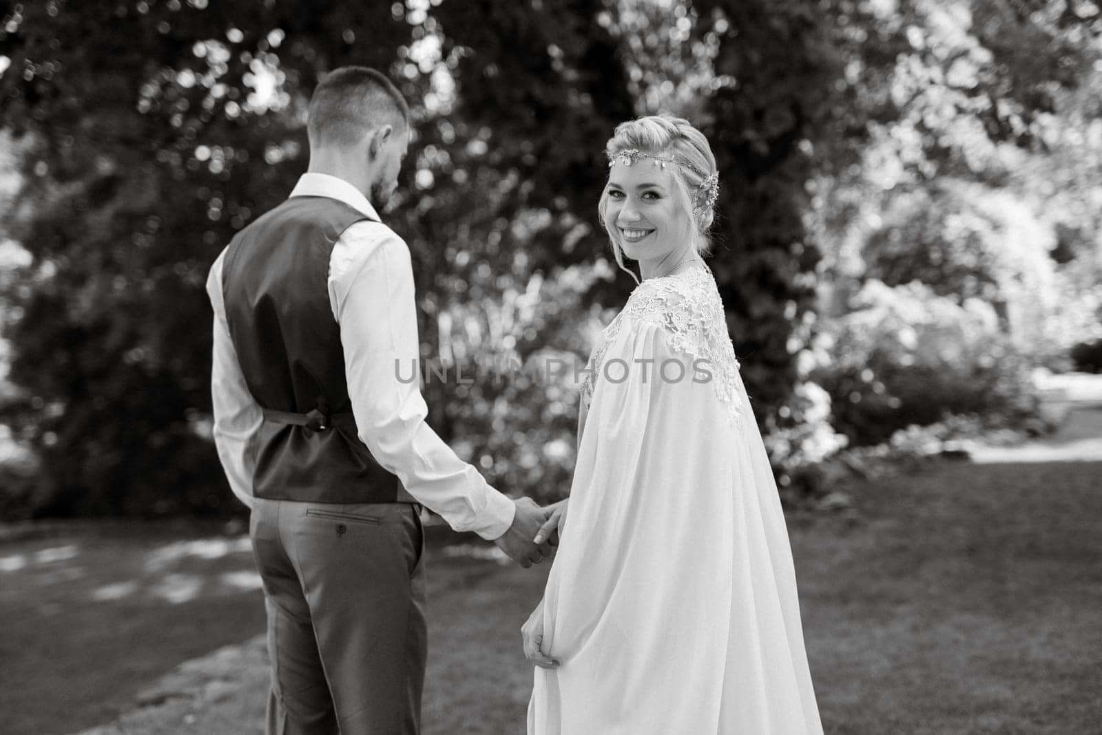 wedding walk of the bride and groom in a coniferous park in summer in elven accessories