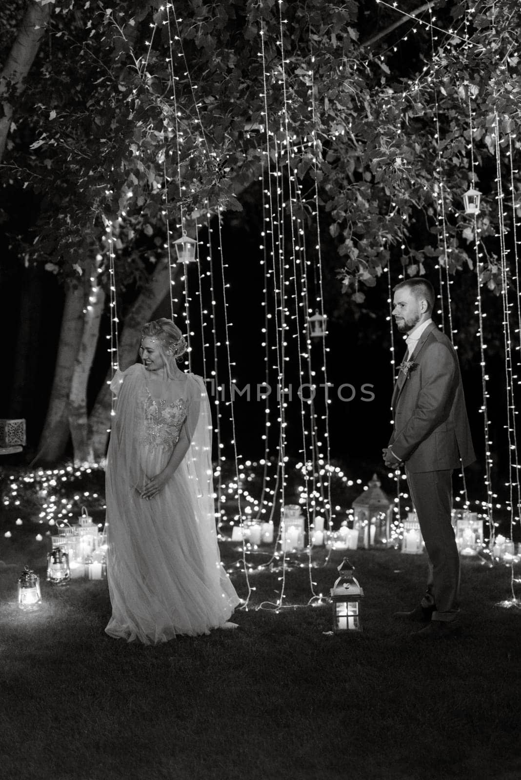 night wedding ceremony of the newlyweds in a country cottage on a green hill