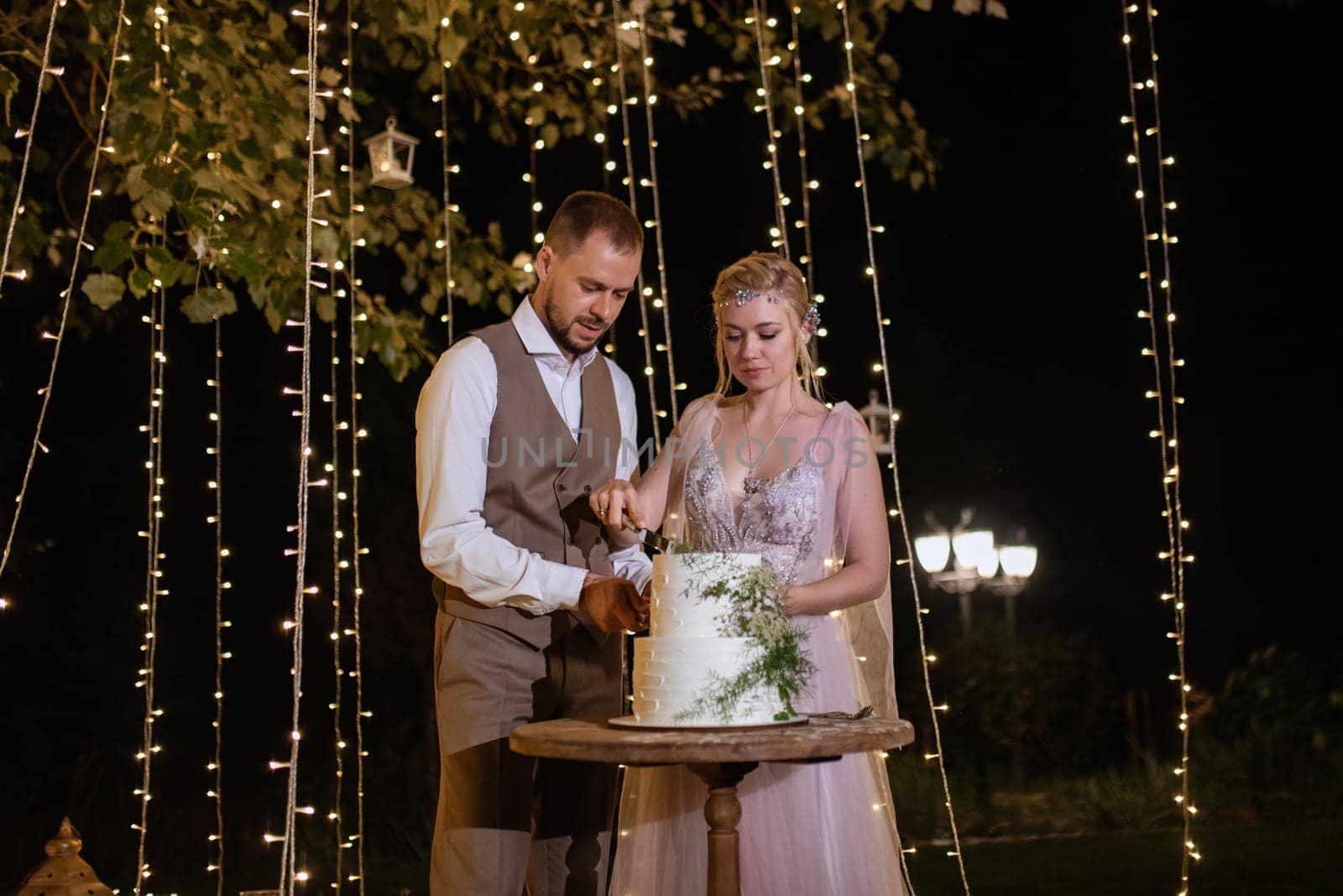 newlyweds happily cut, laugh and taste the wedding cake