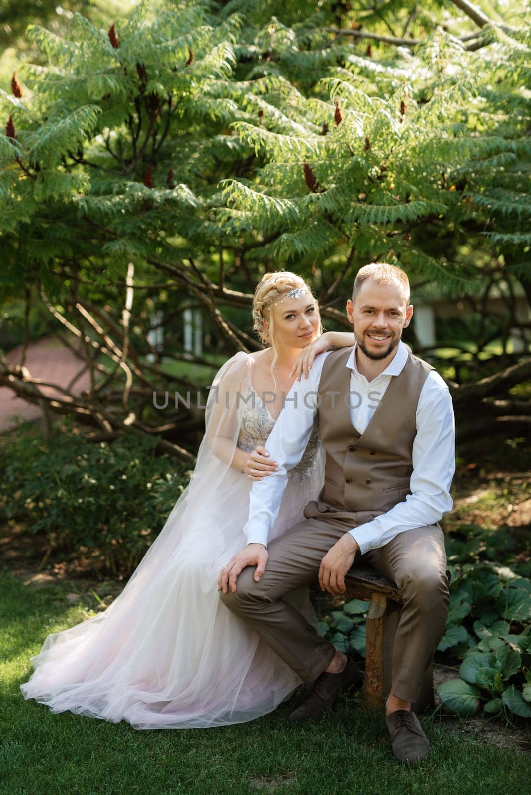 wedding walk of the bride and groom in a coniferous park in summer in elven accessories