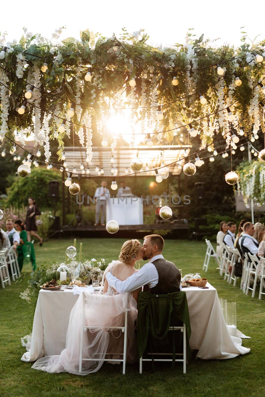 evening wedding family dinner in the forest with light bulbs and candles