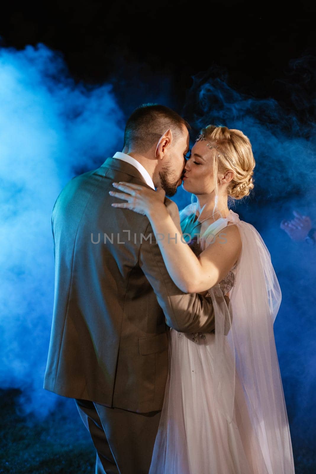 the first wedding dance of the bride and groom in the glade of the country club in the light of sunset and warm garlands