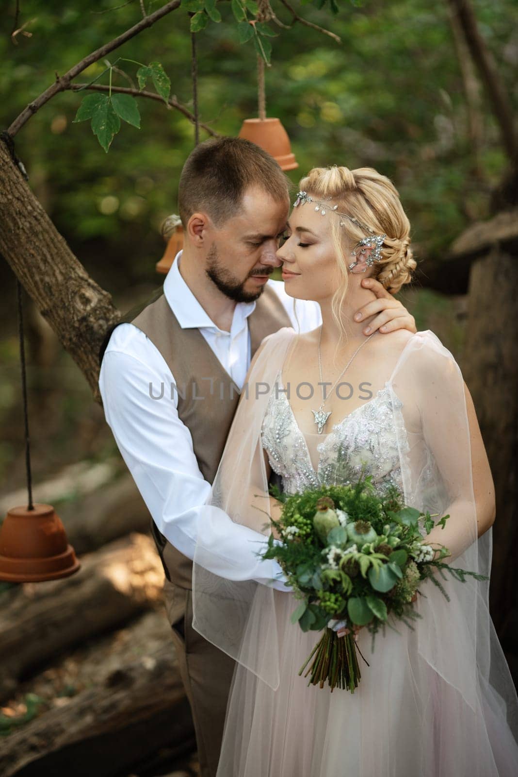 wedding walk of the bride and groom in a coniferous park in summer in elven accessories