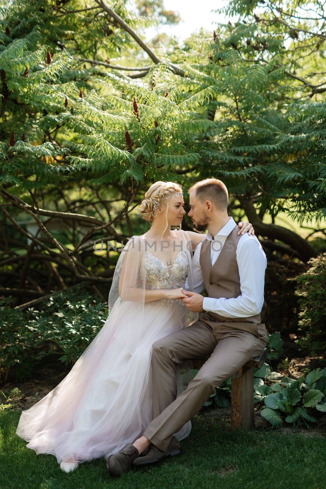 wedding walk of the bride and groom in a coniferous park in summer in elven accessories