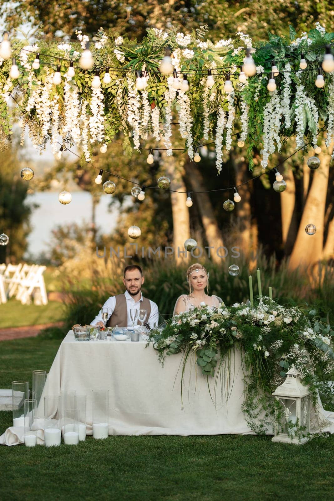 evening wedding family dinner in the forest with light bulbs and candles