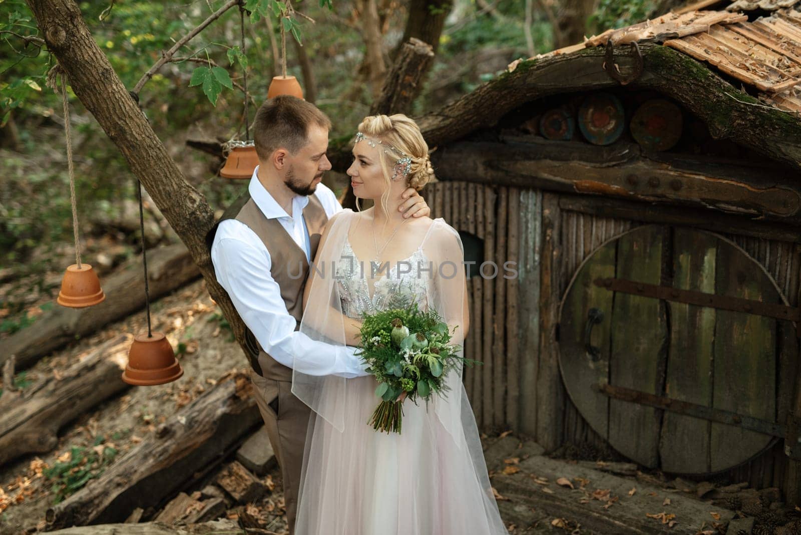 wedding walk of the bride and groom in a coniferous park in summer in elven accessories